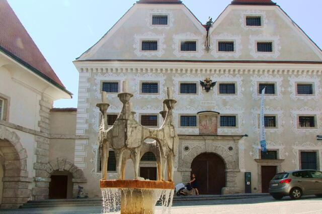 Häuser beim Stadttor und Brunnen