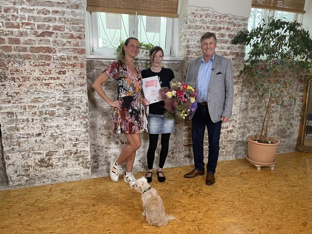 Von "W24"-Moderatorin Mel Merio (l.) und Bezirkschef Erich Hohenberger (SPÖ) gab es Blumen und eine Urkunde für Holzinger. | Foto: Winterthaler/MeinBezirk