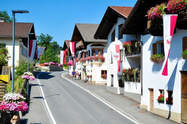 Die Dorfstraße präsentiert sich nach erfolgter Sanierung in bestem Zustand – Blumen- und Fahnenschmuck tragen dazu bei. | Foto: Hassl