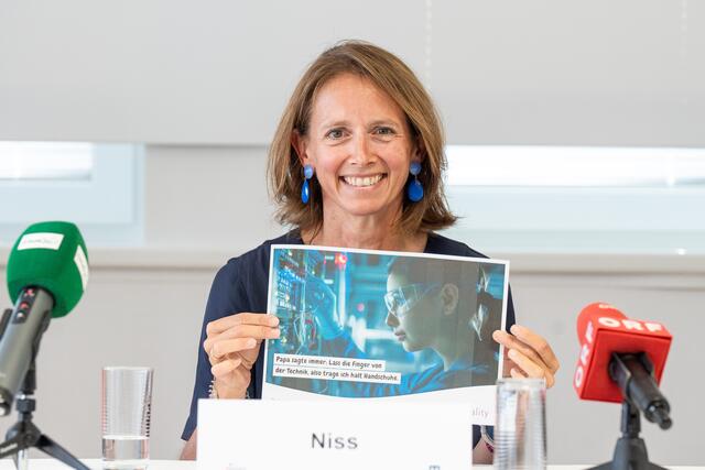 Therese Niss zeigt ein Poster der aktuellen Kampagne der MINTality Stiftung. | Foto: Harald Tauderer