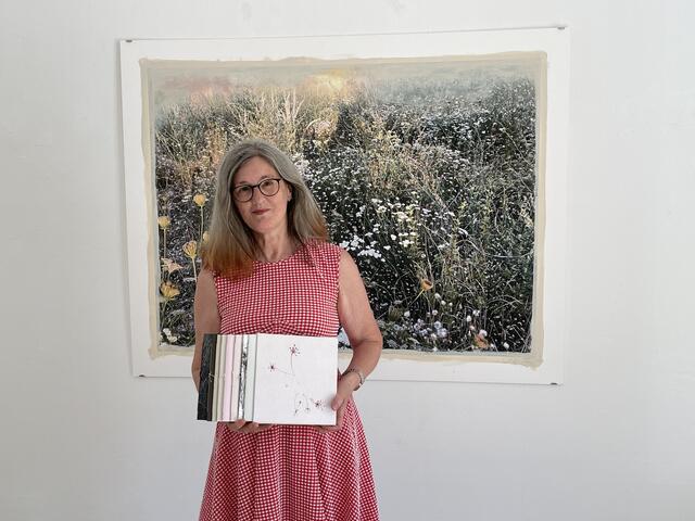 Renate Anzenberger mit ihren "Gstettn"-Büchern vor einem ihrer Kunstwerke. | Foto: Karl Pufler/MeinBezirk