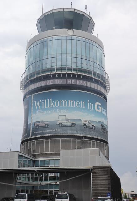 Der Tower am Flughafen Graz ist ein weithin sichtbares Zeichen des Willkommens in Graz. Wollen Reisende allerdings ökologisch per Bahn anreisen, müssen sie gut bei Fuß sein. Der Bahnhof Feldkirchen liegt 300 m entfernt, hingegen fährt die Koralmbahn künftig unterirdisch direkt am Flughafen vorbei.  | Foto: Edith Ertl