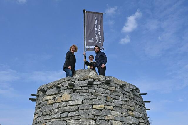 Bildungs-Landesrätin Christiane Teschl-Hofmeister, Vino-HAK-Schüler Felix Bockberger und Trockensteinmauern-Experte Rainer Vogler vor dem imposanten Steinturm

 | Foto: Jürgen Mück