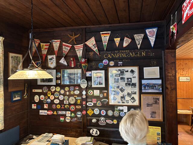 Viele Gäste lassen etwas zurück, in Form eines Wimpels oder Pickerl oder es gibt auch zahlreiche Fotos, wie jenes einer Motorradgang, die seit Jahrzehnten jedes Jahr kommt. Die Wand ist im Wirtshaus zu bestaunen. | Foto: Schrofner