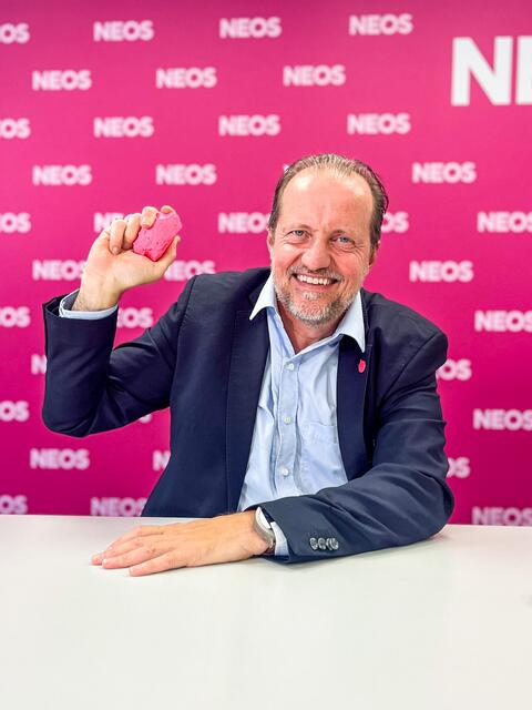 In Anspielung auf den umstrittenen Sager vom dritten Landtagspräsidenten Peter Binder (SPÖ) – "wer in der Politik noch nie gelogen hat, der werfe den ersten Stein" – zückt Georg Redlhammer bei einer Pressekonferenz einen pinken Stein. | Foto: Neos Linz