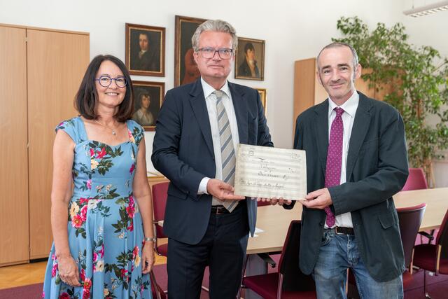 Elisabeth Schöggl-Ernst, LH Christopher Drexler und Paul Duncan mit Mozarts Werk | Foto: Land Steiermark/Binder