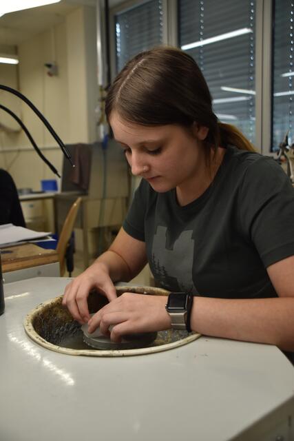 Präzise Handarbeit: Darleen Lucke schleift Glaslinsen mit höchster Genauigkeit – ein entscheidender Schritt in der Herstellung optischer Geräte bei SWAROVSKI OPTIK.