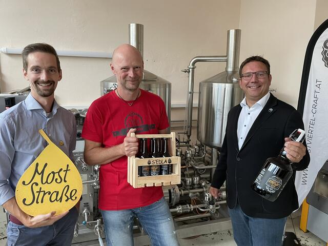 Bürgermeister Christian Haberhauer und Moststraße-Projektleiter Hannes Schoberberger gratulieren Joachim Schnabel zum zehnten Jubiläum von s’Edla Craft Bier | Foto: Moststraße