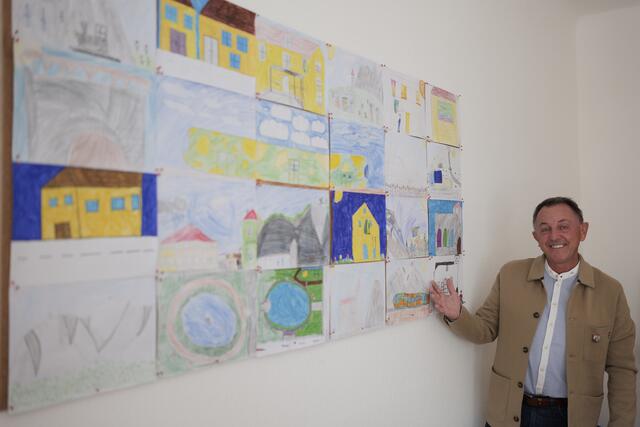 Bürgermeister Christian Dungl vor seiner, mit Kinderzeichnungen geschmückten, Wand im Büro. | Foto: Santrucek