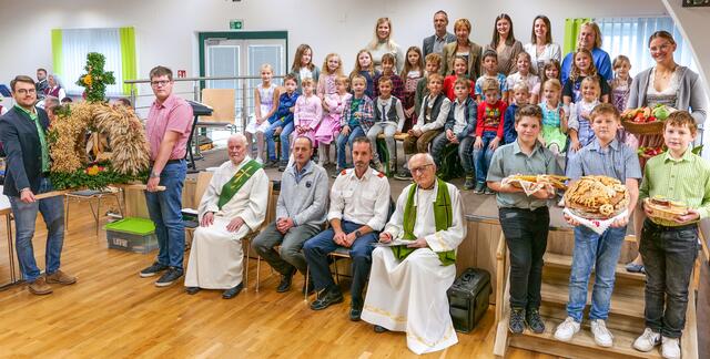 Bernd Weinberger und Christian Schuecker (stehend mit der Erntekrone), Diakon Josef Trinko, Mesner Gerhard Löffler, FF-Kommandant Michael Annerl, Pfarrer Stephan Jarczyk (sitzend) und
Raphael Gruber, Michael Schuecker, Raphael Wallisch, Lisa Weinberger (stehend mit den Gabenkörben). Dahinter die Volksschulkinder mit dem Lehrpersonal
 | Foto: Pfarre Pfaffenschlag