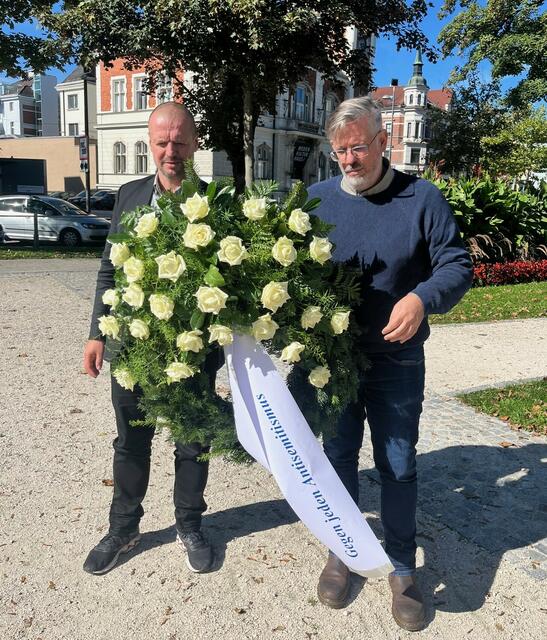 Zum Gedenken an die Opfer des Massakers am 7. Oktober in Israel vergangenen Jahres legen Stadtrat Thomas Rammerstorfer (re.) und Nationalrat Ralph Schallmeiner (li.) einen Kranz in Wels nieder. Der soll auch als Zeichen gegen Antisemitismus stehen. | Foto: Rammerstrofer