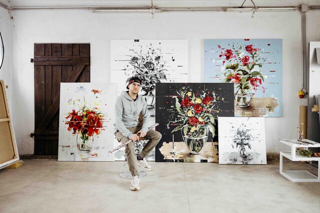 Hier sieht man Georg Pummer mit Werken aus seiner floralen Stillleben-Serie, die seinen markanten Glitch-Stil widerspiegeln.  | Foto: Gerhard Pfeffer