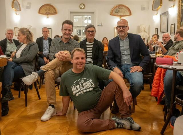 (Bildmitte v.l.n.r.): Markus Stockmaier sowie Dagmar und Stefan Binder stellten sich im Kaffeehaus von Kurt Leitner (liegend) vor.

 | Foto: netwerkstatt/Werner Krauß