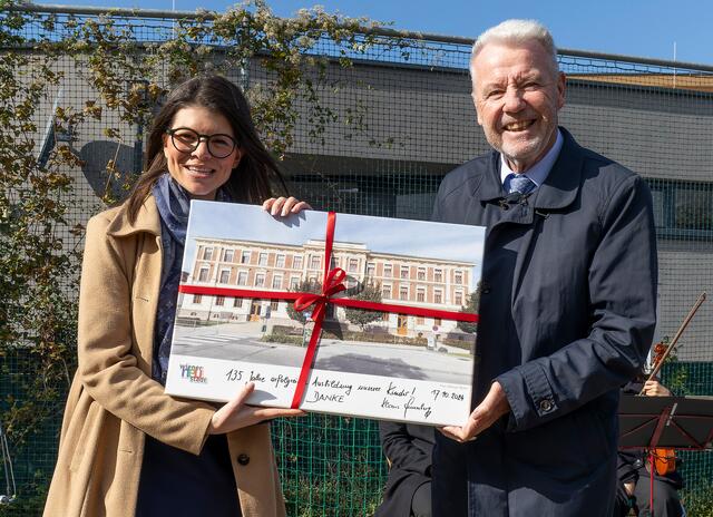 VS Baumkirchnerring-Direktorin Jasmin Steinböck bekam von Bürgermeister Klaus Schneeberger ein Bild der Volksschule auf Leinwand. | Foto: Stadt Wiener Neustadt/Weller