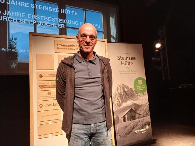 Bernd Noggler, Vorstand des Alpenvereines Landeck! Im Hintergrund die Namen der Unterstützer (Bausteinaktion) der Steinseehütte