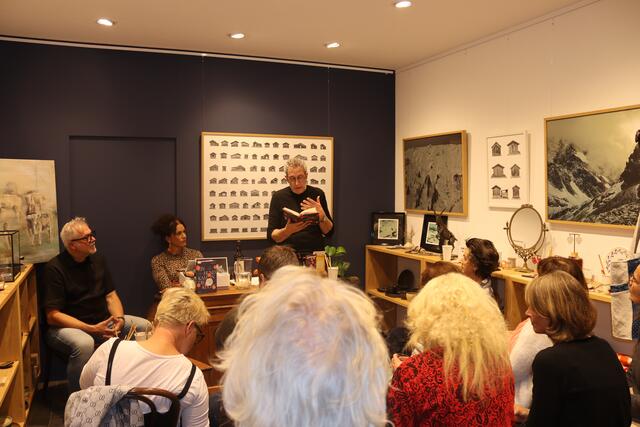 Sepp Mall im Rahmen seiner Lesung in der "muse" in St. Anton am Arlberg, links zu sehen sind die Gastgeber Edgar und Sonja Mall.  | Foto: Elisabeth Zangerl