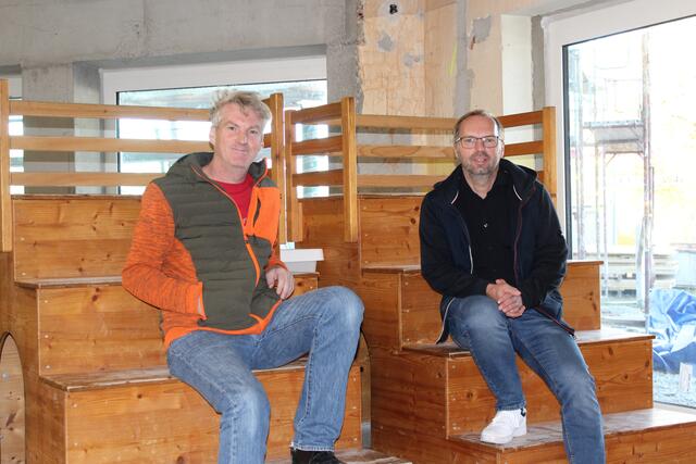 Die Holzbänke, auf denen Volksschuldirektor Wolfgang Neumüller (l.) und Bürgermeister Michael Spörker (r.) sitzen, befinden sich in der zukünftigen Aula. | Foto: MeinBezirk/Roland Wolf
