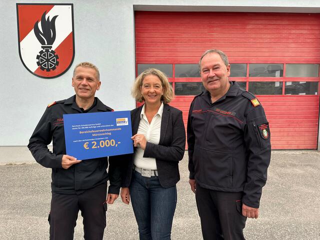 Eva Kasper (faircheck) überreicht den Spendenscheck an Rudolf Schober (links) und Johann Eder-Schützenhofer vom Bereichsfeuerwehrkommando Mürzzuschlag. | Foto: Faircheck