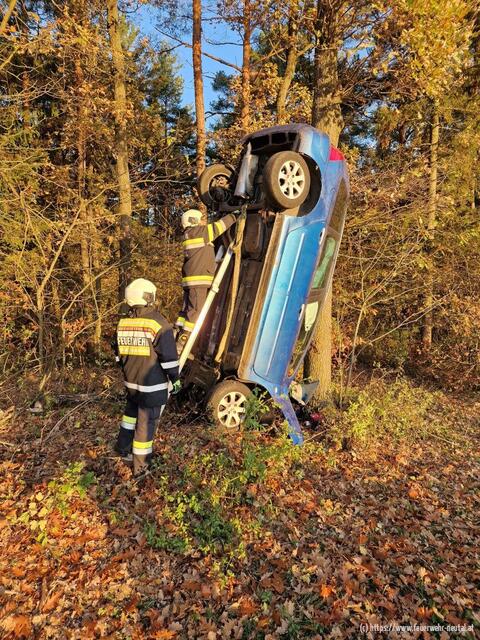 Das Auto blieb vertikal an einem Baumstamm hängen. Zwei Insassen mussten verletzt ins Krankenhaus gebracht werden.  | Foto: Feuerwehr Neutal