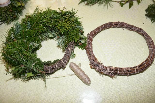  Die Reifen werden aus Birkenreisig geformt. Einzeln legen nun die Frauen die grünen duftenden Zweige rund um den Reifen...