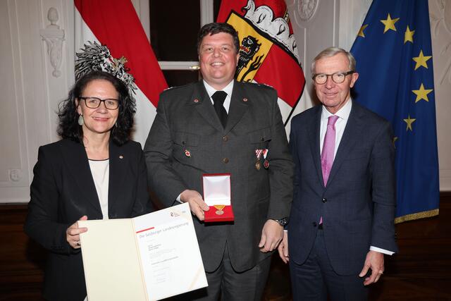 Landeshauptmann Wilfried Haslauer und Landesrätin Daniela Gutschi bei der Überreichung der Feuerwehr- und Rettungsmedaille für 25 Jahre an Hauptzugsführer Martin Engel aus Lessach.  | Foto: Land Salzburg/Franz Neumayr