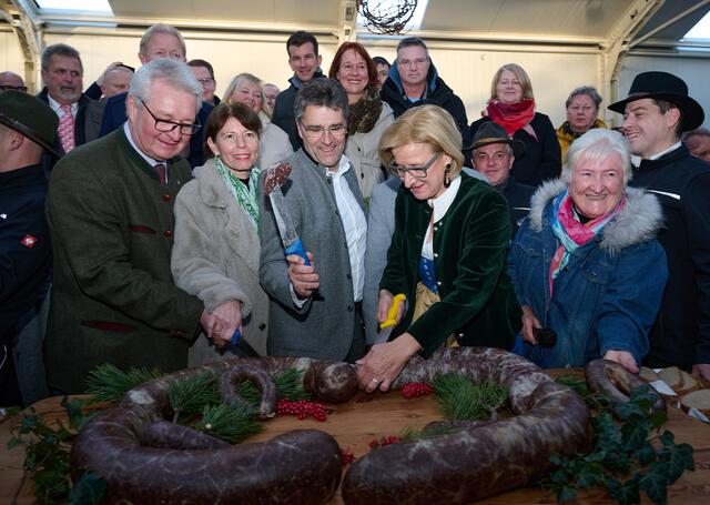Landeshauptfrau Johanna Mikl-Leitner eröffnet den 46. Blunzenkirtag in Großau-Bad Vöslau traditionell mit dem Anschnitt der „Riesenblunze“, unterstützt von (v.l.n.r.) Christoph Kainz, Landtagsabgeordneter und Bürgermeister von Pfaffstätten, Bezirkshauptfrau Verena Sonnleitner, dem Bad Vöslauer Bürgermeister Christian Flammer und Kurdirektorin i.R. und Organisatorin des Kirtags Maria Haarhauer. | Foto: NLK Pfeiffer