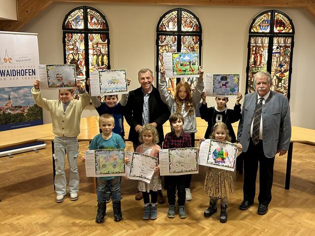 Stella Reuille-Romprè, Andreas Bittner, Nils Böhm, Bürgermeister Josef Ramharter, Flora Kainz, Romana Steiner, Lena Marchsteiner, Xenia Breinhölder, Emilia Zverjev und Gemeinderat Franz Pfabigan mit den prämierten Zeichnungen.  | Foto: Stadtgemeinde Waidhofen