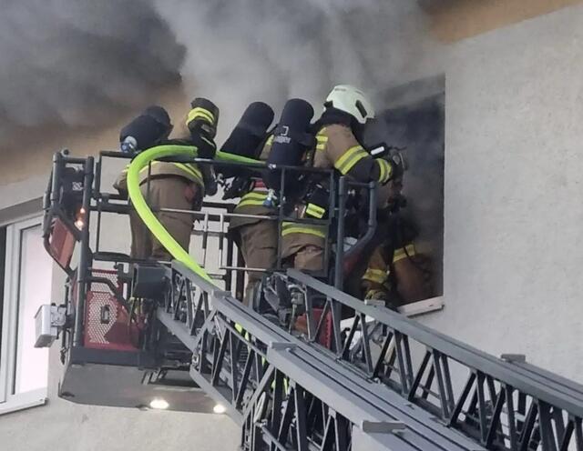 Einsatzkräfte dringen mit der Drehleiter und Atemschutzgerät in die Brandwohnung vor. | Foto: FF Zell am See