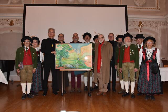 Präsentation des Originalbildes von Renato Ischia aus Arco im barocken Stadtsaal in Hall in Tirol. Umrahmt von den Marketenderinnen und Schützenkameraden der welschtiroler Schützenkompanie "Erzherzog Albrecht zu Arco" - vlnr: Ludwig Spötl (Komitee der NJEK - Partisaner Garde), Pater Volker (Präses der Marianischen Kongregation/Part.-Garde), Mag. Fritz Tiefenthaler (Euregio Tirol), Ivan Benuzzi (Hauptmann der Schützenkompanie Arco), Maestro Renato Ischia aus Arco (Künstler der NJEK 2025) und Dr. Christian Margreiter (Bürgermeister der Stadt Hall in Tirol) | Foto: Stadtamt Hall
