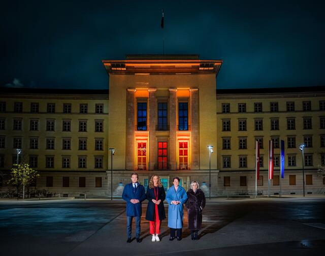 Landtagspräsidentin Sonja Ledl-Rossmann (3.v.li.), Vizepräsidentin Elisabeth Blanik (4.v.li.), Vizepräsident Dominik Mainusch und LRin Eva Pawlata vor dem orange beleuchteten Landhaus | Foto: Tiroler Landtag/Christanell