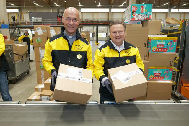 Versprechen eingelöst: Dompfarrer Faber (l.) und Bürgermeister Ludwig als "helfende Elfen" im Logistikzentrum der Post in Liesing. | Foto: Maximilian Spitzauer/MeinBezirk