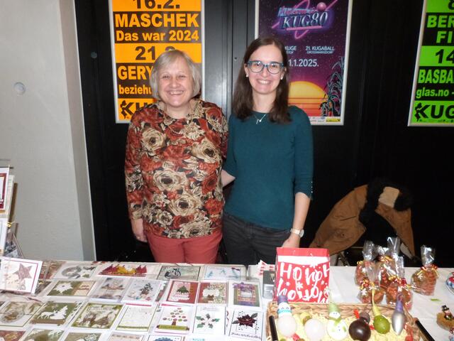 Im großen Saal versammelten sich zahlreiche Besucher:innen, um Weihnachtsgeschenke zu bewundern und erwerben.