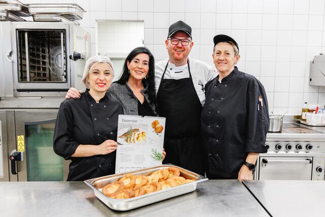 Erstmals  präsentiert die Stadt Salzburg den Rezept-Kalender 2025, der unter dem Motto „Genussvoll durch das Jahr 2025“ steht. Am Bild v.l.n.r.: Elena Hadji-Arsova, Küchenhilfe, Nadine Winkler, Organisation Alltagsbegleitung, Andreas Eberl, Küchenleitung SWH Lehen und Slavica Grujic, Sous Chefin. | Foto: Stadt Salzburg / needful