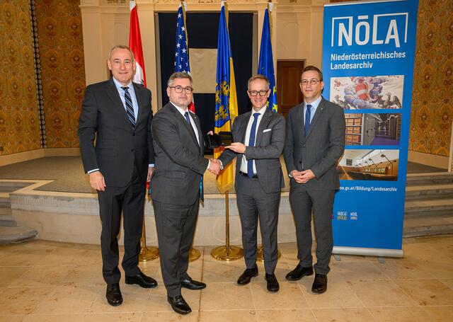 Landesrat Ludwig Schleritzko übergibt symbolisch eine Festplatte mit digitalisierten Holocaust-Dokumenten an Zachary Levine vom US Holocaust Memorial Museum.“ | Foto: NLK/ Burchhart