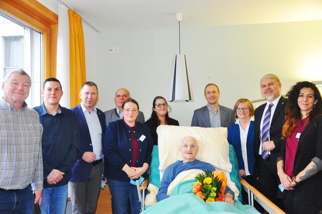 Die Schar der Gratulantinnen und Gratulanten im Zimmer des Jubilars Helmut Heilinger vlnr.:
Ehrenamtlicher Mitarbeiter Karl Wagner; Pflege- und Betreuungsmanager (PBM) Manfred
Schnötzinger; Bgm. der Stadtgemeinde Retz Stefan Lang; Vize-Bgm. der Gemeinde Hadres
Erich Greil; Managerin Ehrenamt und Alltagsbegleitung Isabella Schimak; Pflegedirektorin
Betina Rauscher, MSc; Kaufmännischer Direktor Horst Winkler, MBA; Maria Brandstätter;
Gesundheit Weinviertel GmbH Roman Beisser; PBM Nadine Grill mit dem Jubilar Helmut
Heilinger | Foto: PBZ Retz