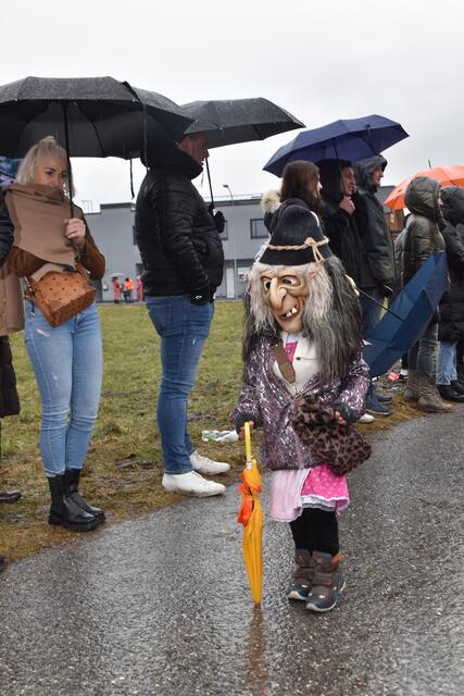 Besucherinnen und Besucher trotzen dem Wetter und feiern den Faschingsumzug mit ausgelassener Stimmung.