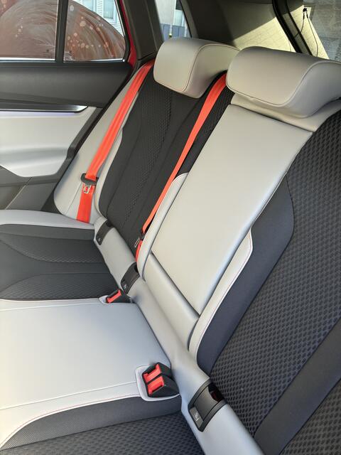 Absoluter Eyecatcher: die orange-roten Gurte und die hellen Sitze.