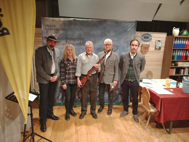 Georg Jenewein aus Tannheim, zog den Hauptpreis, eine Jagdwaffe der Marke „CZ Luxus, Kal. 308“ mit Ebenholzschaft, spendiert vom Waffengeschäft SISO in Reutte. Überreicht wurde der Preis von Helmut Sonnweber (zweiter von recht) und seiner Tochter Nicole vom Waffengeschäft SISO