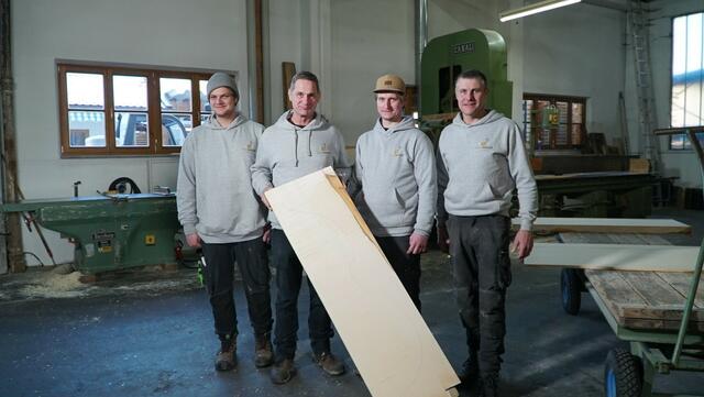 Die Mannschaft von Tonholz Mannes mit Eigentümer Hans-Peter (mitte links) und Sylvester Mannes (mitte rechts) stehen mit einem Ahiornbrett in ihrer Werkstatt | Foto: ServusTV / Degn Film