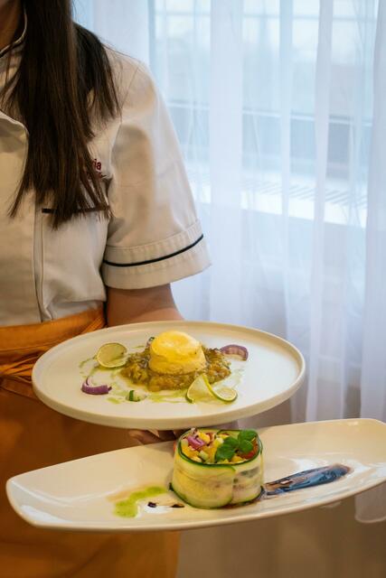 Ziegenfrischkäse-Törtchen mit Avocado-Mango-Salat (Teller oben) und marinierten Mozzarella im Zucchinimantel (Teller unten). | Foto: Julia Liedl