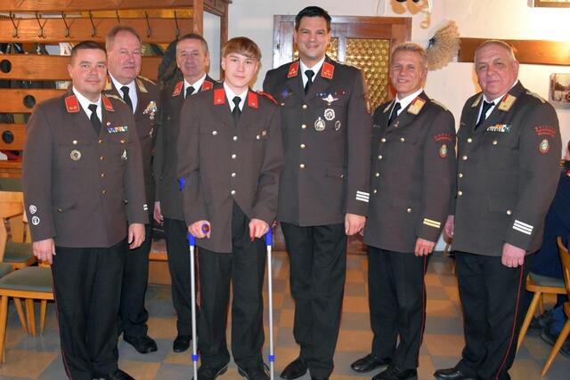 Feuerwehrmann Julian Knaus (mit Krücken) wurde bei der Wehrversammlung angelobt. Im Bild mit dem Kommando der FF Krampen und Ehrengästen. | Foto: BVFMZ/Pusterhofer