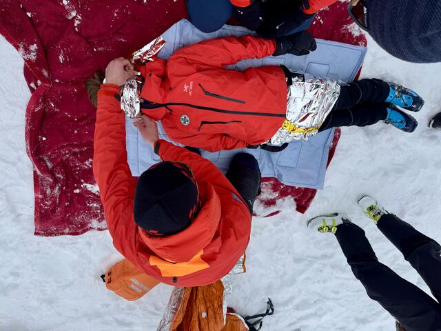 Das Lawinenopfer wird nach der Bergung warm eingepackt. | Foto: Markus Wolf/Adolf Kerber