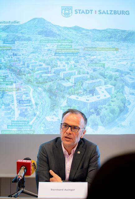Bürgermeister Bernhard Auinger und im Hintergrund eine Idee der Stadtplaner, wie die Goethesiedlung in Zukunft aussehen könnte. Mit einem Neubau auf dem Parkplatzareal und viele Grünflächen. | Foto: Stadt:Salzburg - Alexander Killer