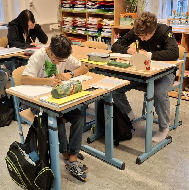 Kleingruppenschüler mit neuen Schulmöbeln.
