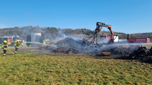 Um den Brand effektiver bekämpfen zu können, wurde der Holzhaufen mithilfe eines Holzgreifers auseinandergezogen.  | Foto: FF Gössendorf