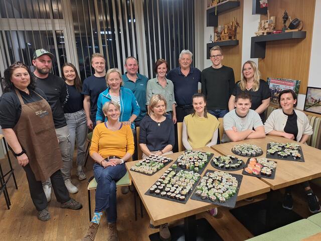 Stolz präsentieren die Teilnehmer:innen vom Sushi-Workshop und Kursleiter Manfred Folie (Mitte) ihre selbst gemachten Maki und Nigiri 