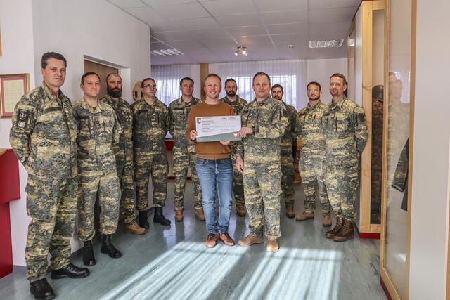 Stabswachtmeister Josef Müllegger, der für den Pionieradvent verantwortliche Unteroffizier, übergibt im Beisein der Vertreter der Kompanien des Pionierbataillon 2 unter Bataillonskommandanten Oberstleutnant Klaus Rosenkranz (ganz rechts) den Spendenscheck an Dominik Steinbichler von der Salzburger Kinderkrebshilfe.   | Foto: Bundesheer/Hannes Brandl