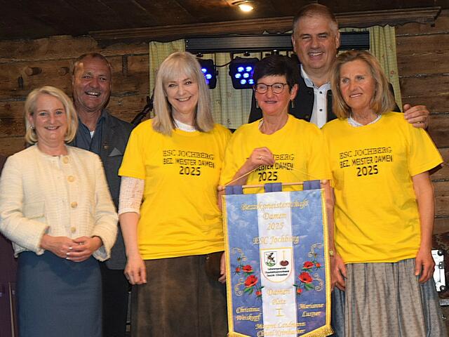 Vierer Mannschaft  Bezirksmeisterinnen 2025 die Damen des ESC Jochberg vl. Frau Landtagsabgeordnete Claudia Hagsteiner , Gemeinde Vertreter Hanspeter Ellmerer, und der stolze Jochberg Bürgermeister Günter Resch, mit den Siegerinnen Marianne Luxner, Margret Landmann und Christl Krimbacher, nicht im Bild Christina Weißkopf.