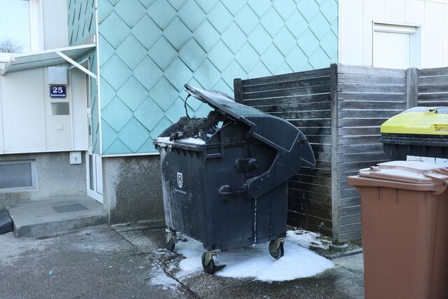 Brennender Altpapiercontainer in Wels-Lichtenegg: Durch das Einschreiten der Feuerwehr konnte ein Übergreifen der Flammen auf die Fassade verhindern.