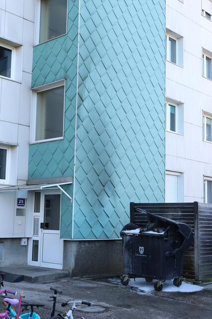 Brennender Altpapiercontainer in Wels-Lichtenegg: Durch das Einschreiten der Feuerwehr konnte ein Übergreifen der Flammen auf die Fassade verhindern.